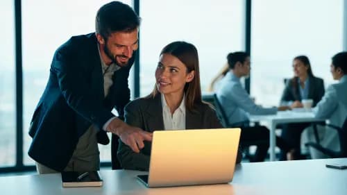 IT-Experte unterstützt Kleinunternehmer bei Einrichtung moderner Software am Laptop im Büro