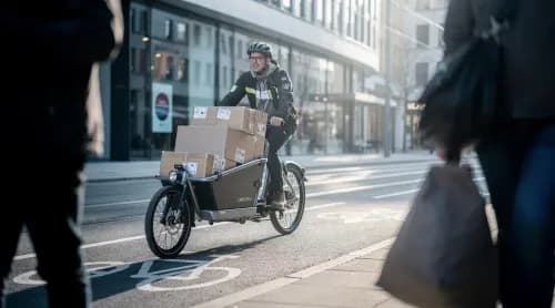 Kurier liefert Pakete emissionsfrei per E-Lastenrad durch die Innenstadt aus